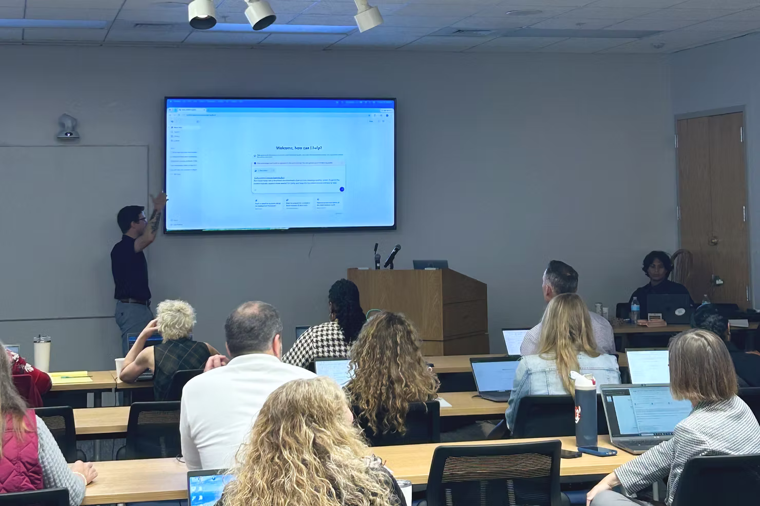 Arvaya trainer pointing to Microsoft Copilot on a wall screen as Charleston County staff follow along on laptops in a training room