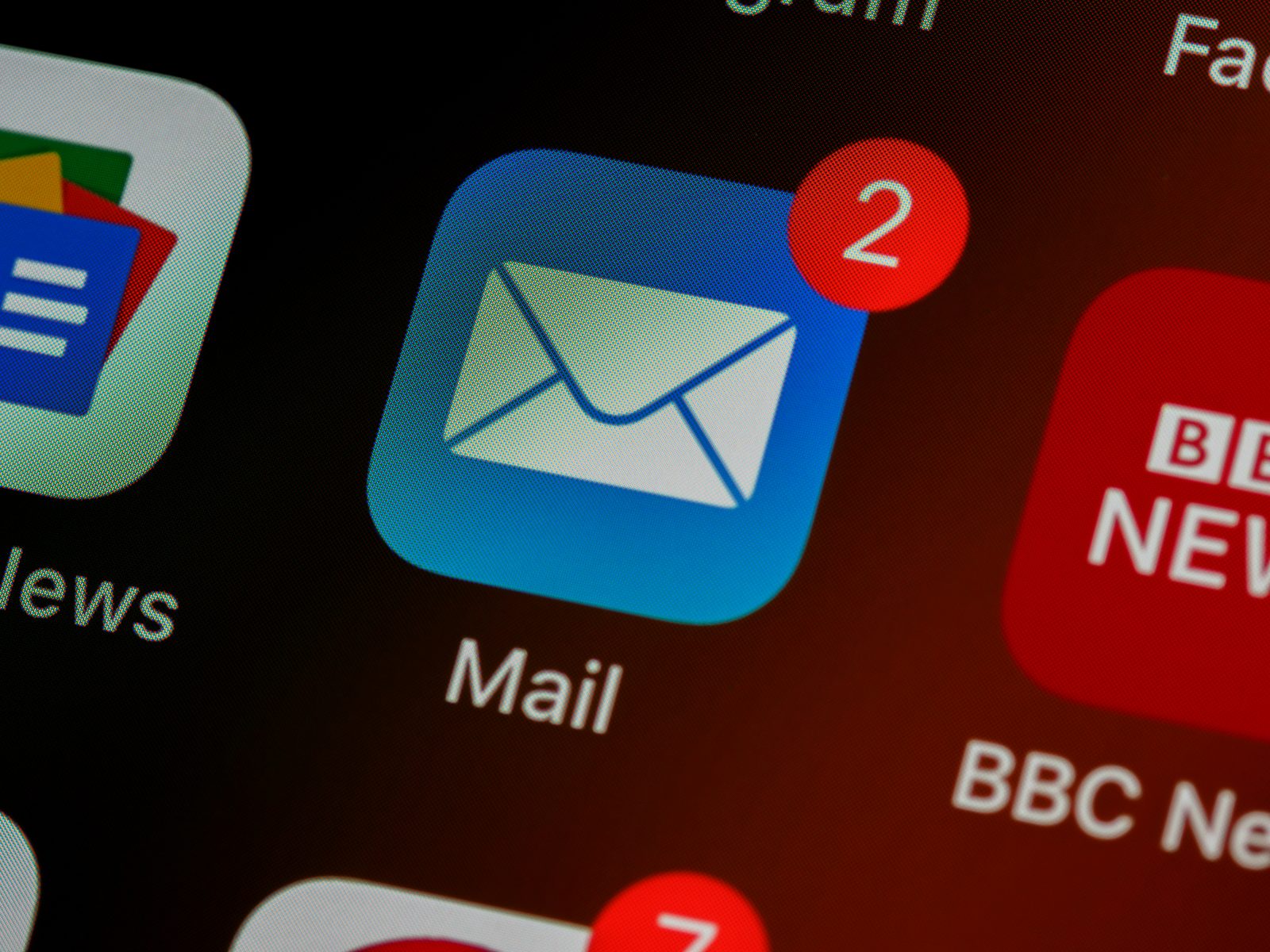 Close-up of a smartphone home screen showing the Mail app icon with two unread email notifications